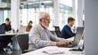 © Robert Kneschke - Senior businessman working on laptop in modern office setting