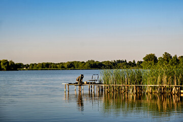 Canvas Print - a chair on an old wooden dock in the water on the lake.