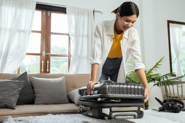 Young woman sit in floor and preparation suitcase for travelling at weekend trip