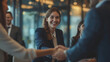 Teamwork and Technology: Group of young business people standing in the office, rejoicing at the deal struck. Man shaking hands with a woman, concluding a meeting, signing a contract, or welcoming a n