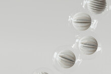 3D Render Of Plastic Wrapped Spheres Floating Against White Background