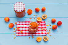 Homemade Apricot Jam With Marigoldpetals And Raw Apricots On Blue Wood