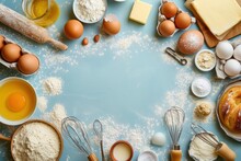Top View Of Various Bakery Ingredients And Items Such As Eggs, Butter, Flour, Sugar, Rolling Pin, Measure Cups, Hand Whisk And Serving Scoop 