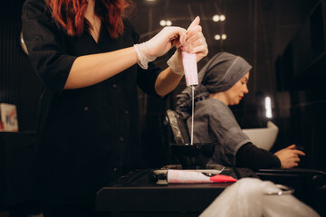 Tools for hair dyeing in woman hands. Colouring of hair at home