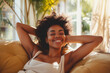 Happy afro american woman relaxing on the sofa at home - Smiling girl enjoying day off. Healthy life style, new home concept.