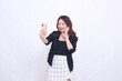 © Ajab - Beautiful Indonesian office woman in her 20s with a cheerful expression looking at her cream colored cellphone gadget while making a video call for a promo isolated on a white background