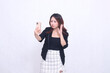 © Ajab - beautiful Indonesian office woman in her 20s with a sad expression looking at her cream colored cellphone gadget while making a video call for a promo isolated on a white background