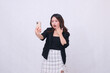 © Ajab - beautiful Indonesian office woman in her 20s with a shocked expression looking at her cream colored cellphone gadget while making a video call for a promo isolated on a white background