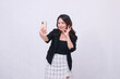 © Ajab - beautiful Indonesian office woman in her 20s smiling expression okay looking at her cream colored cellphone gadget while making a video call for a promo isolated on a white background
