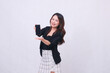 © Ajab - beautiful Indonesian office woman 20s smiling expression promoting cell phone gadget screen in front for promo with hands underneath isolated on white background