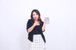© Ajab - beautiful Indonesian office woman 20s expression of surprise on promotion of cellphone gadget screen for promo while pointing at it underneath isolated white background