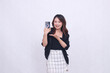 © Ajab - the charm of a beautiful Asian office woman in her 20s, cheerful expression, carrying a cellphone gadget facing her back while introducing her hand, isolated on a white background