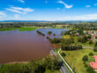 © Austockphoto - Underwater road during flood - dirty brown floodwaters spread over farmland