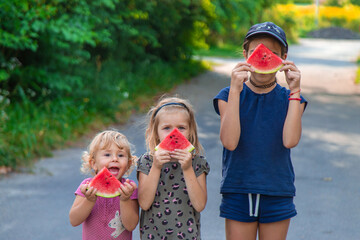 Wall Mural - Children in the park eat watermelon. Selective focus.