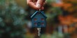 © Iryna - A keychain with a house-shaped key, symbolizing real estate ownership.