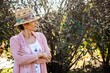 © Austockphoto - Senior woman wearing a hat in the garden looking to the side