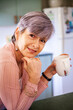 © Austockphoto - Middle aged woman drinking a cup of tea in her kitchen