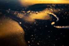 The Sun's Golden Rays Cast A Mystical Glow On Water Droplets, Creating A Bokeh Effect On A Dark Surface