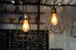 © Nattawit - Classic style lightbulb ceiling lamp with iron cage glowing in orange light shade. Interior decoration object photo, selective focus.
