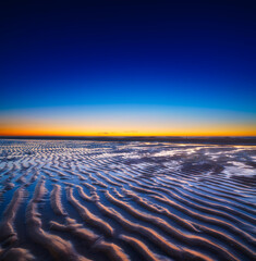 Wall Mural - a seascape during sunset. lines of sand on the seashore. bright sky during sunset. a sandy beach at 
