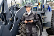 © scharfsinn86 - Serviceman with digital tablet on a background of the tractor.