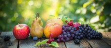 Bio Fruits, Including Apples, Pears, Grapes, And Blackberries, Ripen On A Wooden Table In An Orchard, Against A Garden Backdrop.