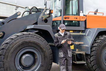 Poster - Serviceman with digital tablet on a background of the tractor.