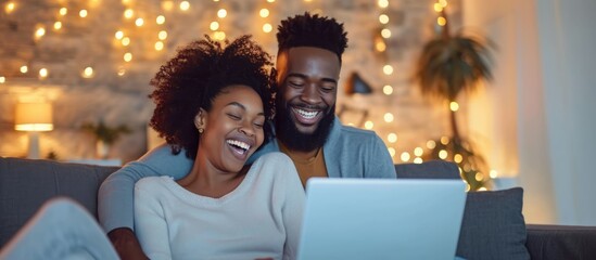 Happy couple using laptop, shopping online, on social media and having fun, laughing on the couch in cozy apartment, empowering women.