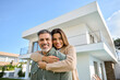 © insta_photos - Happy smiling mature older family couple new property buyers modern dream luxury villa owners standing outside house, affectionate senior middle aged man and woman in love hugging outdoor. Portrait.