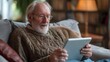 Smiling senior man relaxing on a sofa, browsing on a tablet in a cozy living room with modern decor.