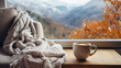 Wide closeup travel banner  of view from a luxury hotel bedroom window, cozy couch with pillows and coffee cup on a tray, misty mountain range landscape outside in a cold day morning