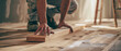 Craftsman carefully installing wooden flooring, attention to detail in home renovation