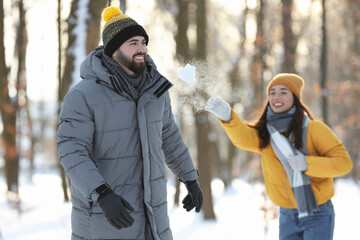 Wall Mural - Happy couple playing snowballs on winter day outdoors