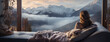 A wide panoramic closeup Facebook banner of a pretty smiling woman holding a coffee cup and drinking near a window and looking outside foggy mountain in a cold day morning 