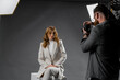 © Big Shot Theory - Model young woman preparing posing for photo taken with professional photographer in studio on fashion concept