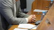 Folded hands of politician or businessman on desk next to documents, speakerphone and microphone. Working meeting with colleagues or negotiations. Without a face. Photo. Selective focus