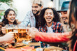 Multi racial hipster friends drinking and toasting beer at brewery bar restaurant - Food and beverage life style concept with men and women having dinner together - Focus on girl with braces