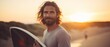 Portrait of a young man with surfboard on the beach at sunset. Sport concept. Vacation and Travel Concept with Copy Space.