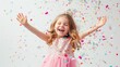 © pvl0707 - exuberance of a little girl in a pink dress catching confetti, smiling happily on a white background.