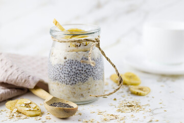 Oatmeal in a jar (lazy oatmeal) with bananas and chia seeds. Healthy breakfast concept.