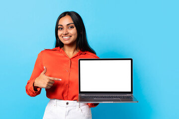 Middle Eastern lady pointing finger at empty computer screen, studio