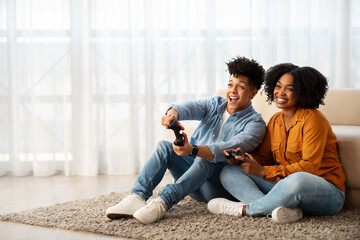 Wall Mural - A cheerful young couple enjoys a playful moment together while sitting on the floor