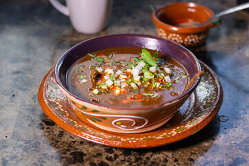 Beef birria with red sauce and vegetables in a traditional Mexican dish. Mexican food