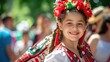 © Anna - Smiling young girl with braids wearing a colorful folk dress and headpiece