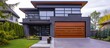 A luxury contemporary house with a dark grey exterior features a modern garage door made to look like brown wood with horizontal glass windows, situated on a concrete driveway.