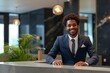 © Alina - Young african american man receptionist standing in hotel lobby near the counter