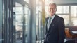 © bomoge.pl - Confident Mature Businessman with a Warm Smile Standing in a Modern Office Environment