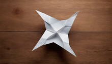 Folded Paper Spinning Top Star On Wooden Table 