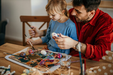 Wall Mural - Dad and daughter engaging in Easter crafting in the dining room