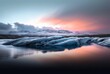 As the sun sets over the glacial lake, the towering icebergs reflect off the crystal clear water, creating a breathtaking landscape of snow, nature, and melting ice in the arctic